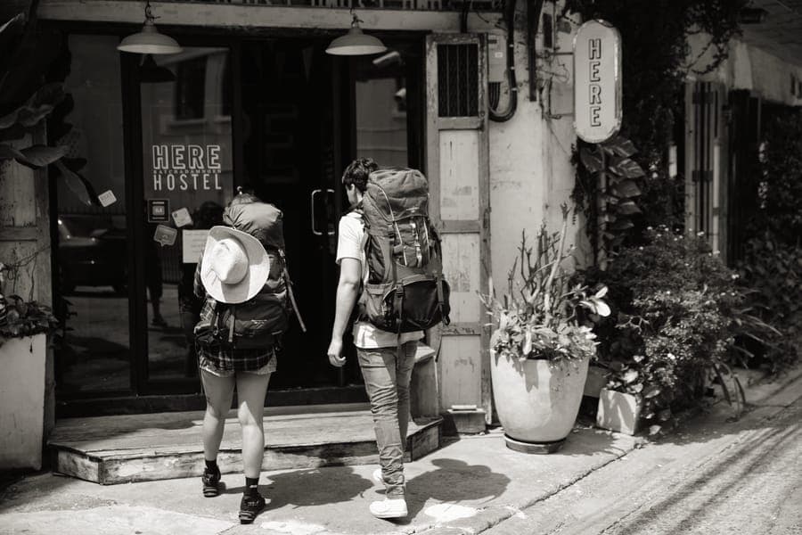 A frameless travel backpack packed and standing upright