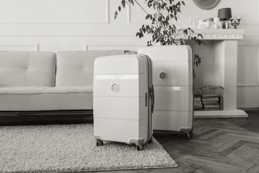 A hardside cabin suitcase standing upright with its handle extended