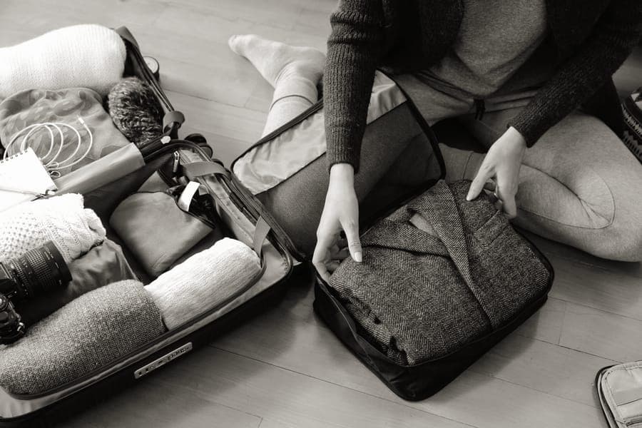 Fabric packing cubes filled with folded clothes inside a suitcase