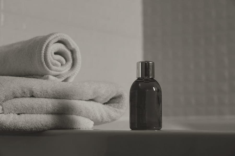 A zipped fabric toiletry bag packed with travel-size bottles